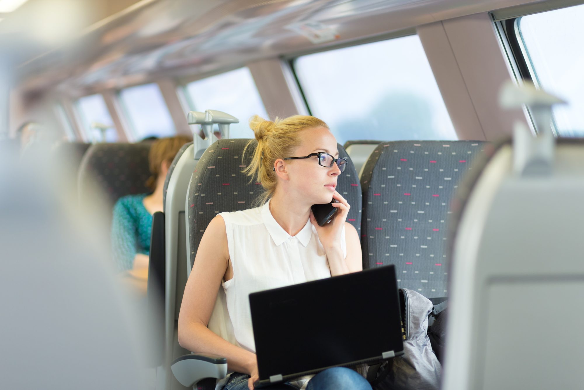 Business woman working while travelling by train.